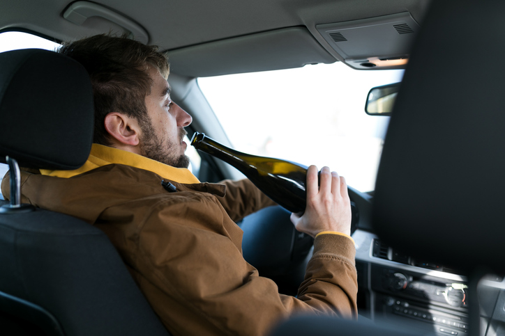 Man drinking beer while driving