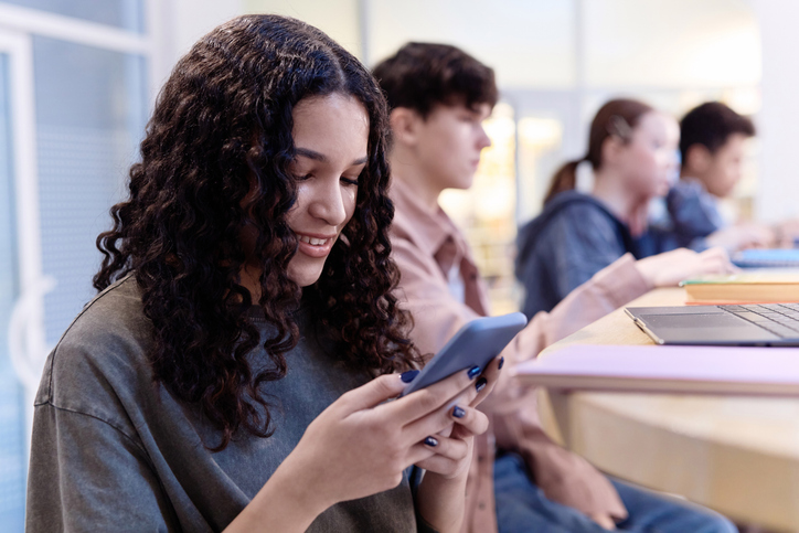 Girl using Smartphone in School Class and Reading Text Messages
