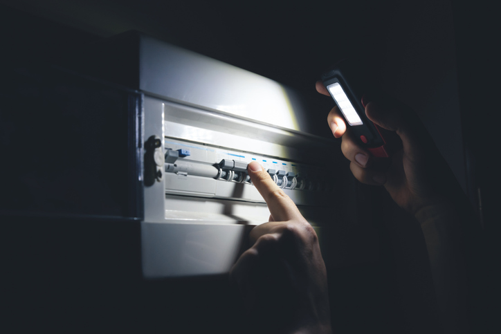 Electrical blackout. Man switching fuses