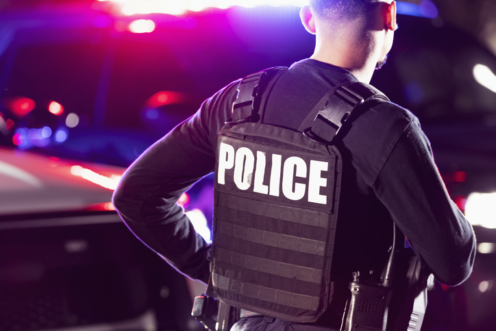 Hispanic police officer working at night