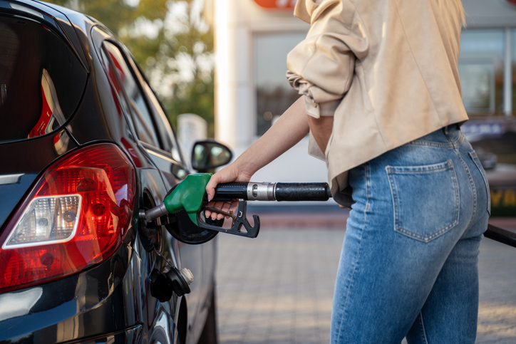 Unrecognizable woman fills up car tank on the gas station