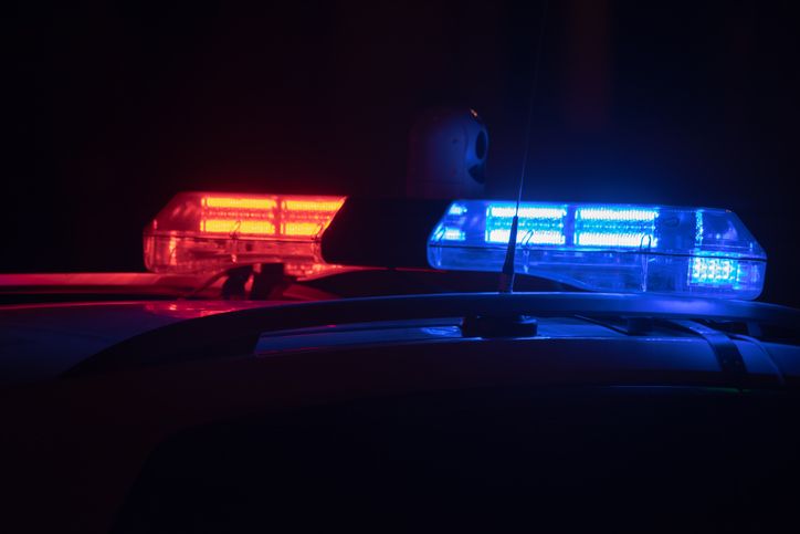 Police car lights at night in city with selective focus and bokeh.