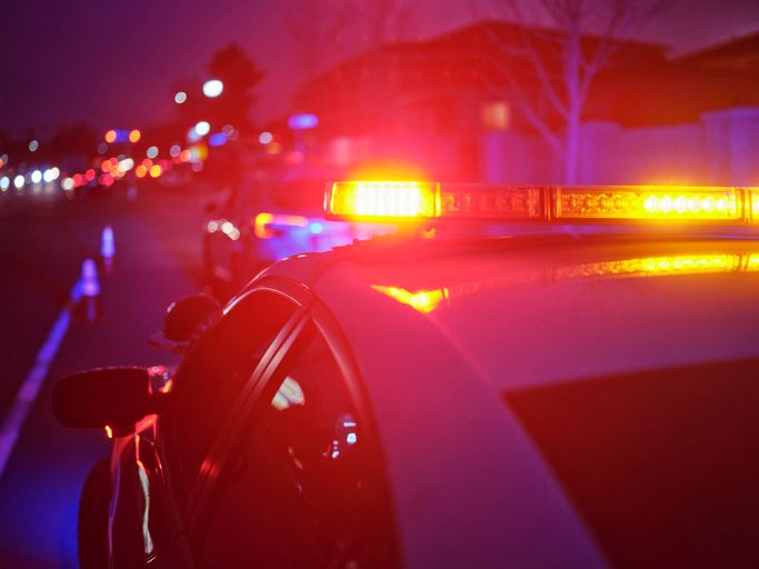 Police Car Stopped on a Road at Night with Emergency Lights