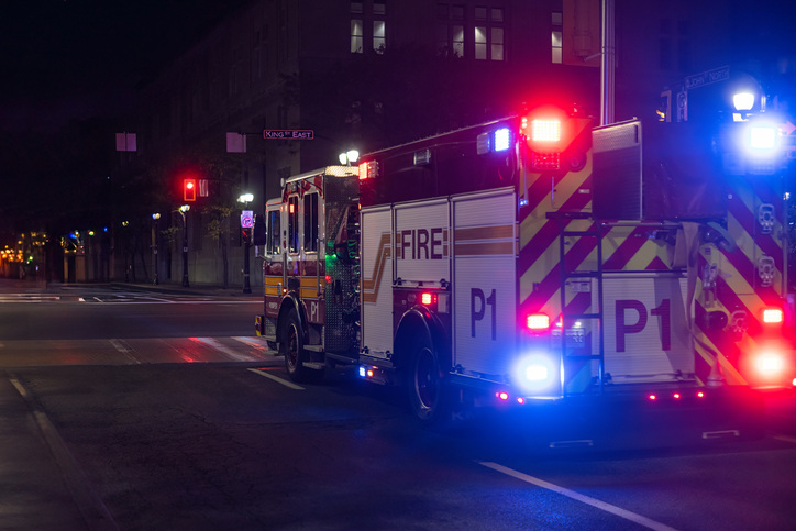 Fire Truck with Sirens and Lights on driving through an intersection at night