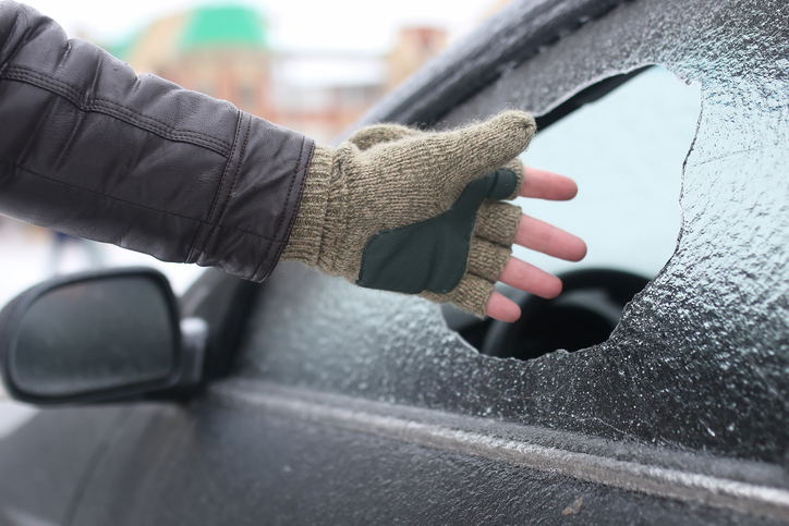 man broke the glass of the car a little stone