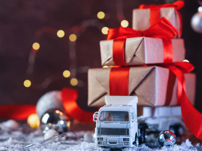 The toy truck is carrying a lot of Christmas gift boxes
