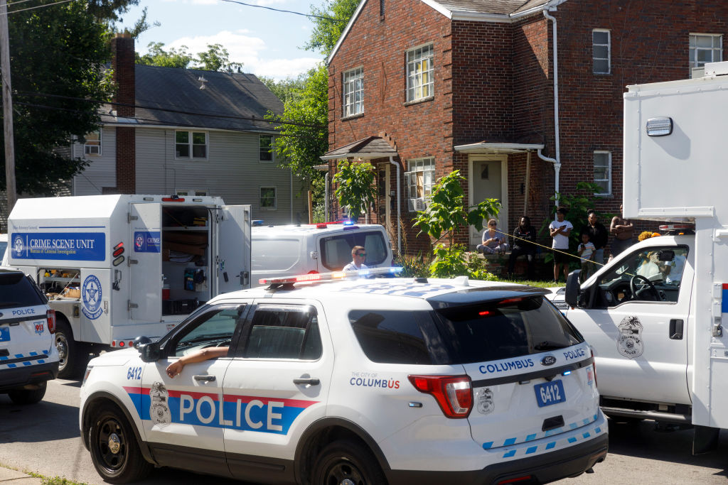 Linden residents gather to watch the police investigate a...