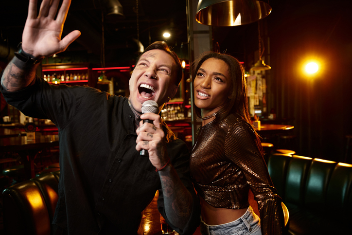 Couple enjoying a lively night of music at a bar filled with romance and laughter
