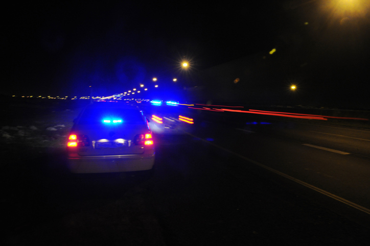 Police cars with blue flashing lights on a night patrol