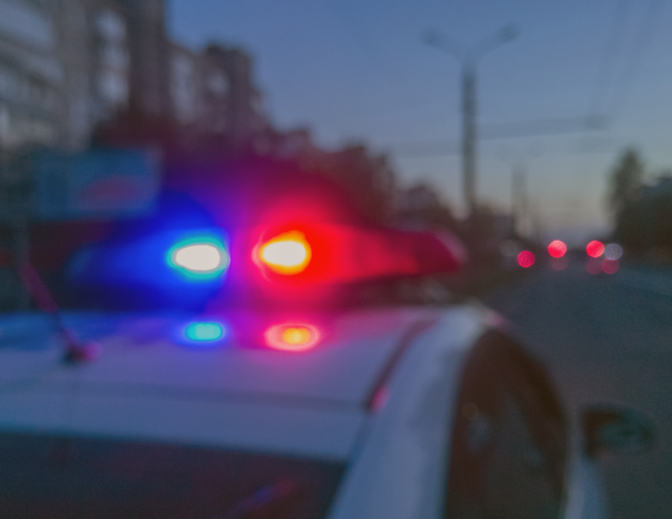 Night patrolling the city. Police car lights in night time, crime scene. Abstract blurry image.