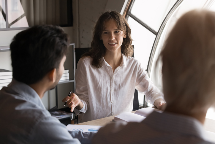 Young professional woman engaged in active discussion with two colleagues