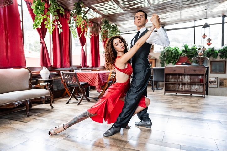 Portrait of a mid adult couple dancing tango in a restaurant