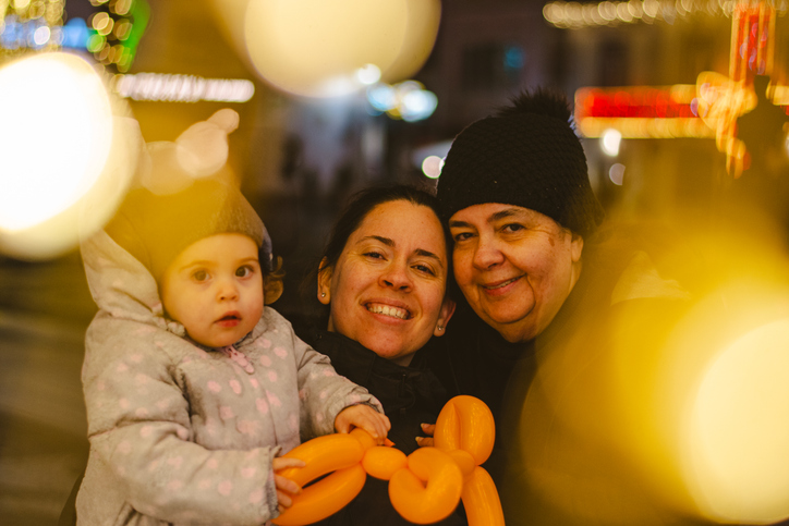 Family portrait in the street surrounded by Christmas lights