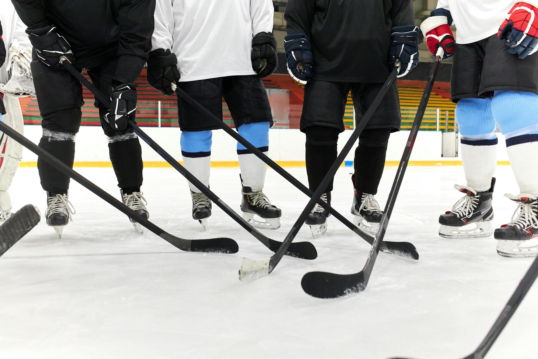 people standing on ice rink while holding hockey sticks