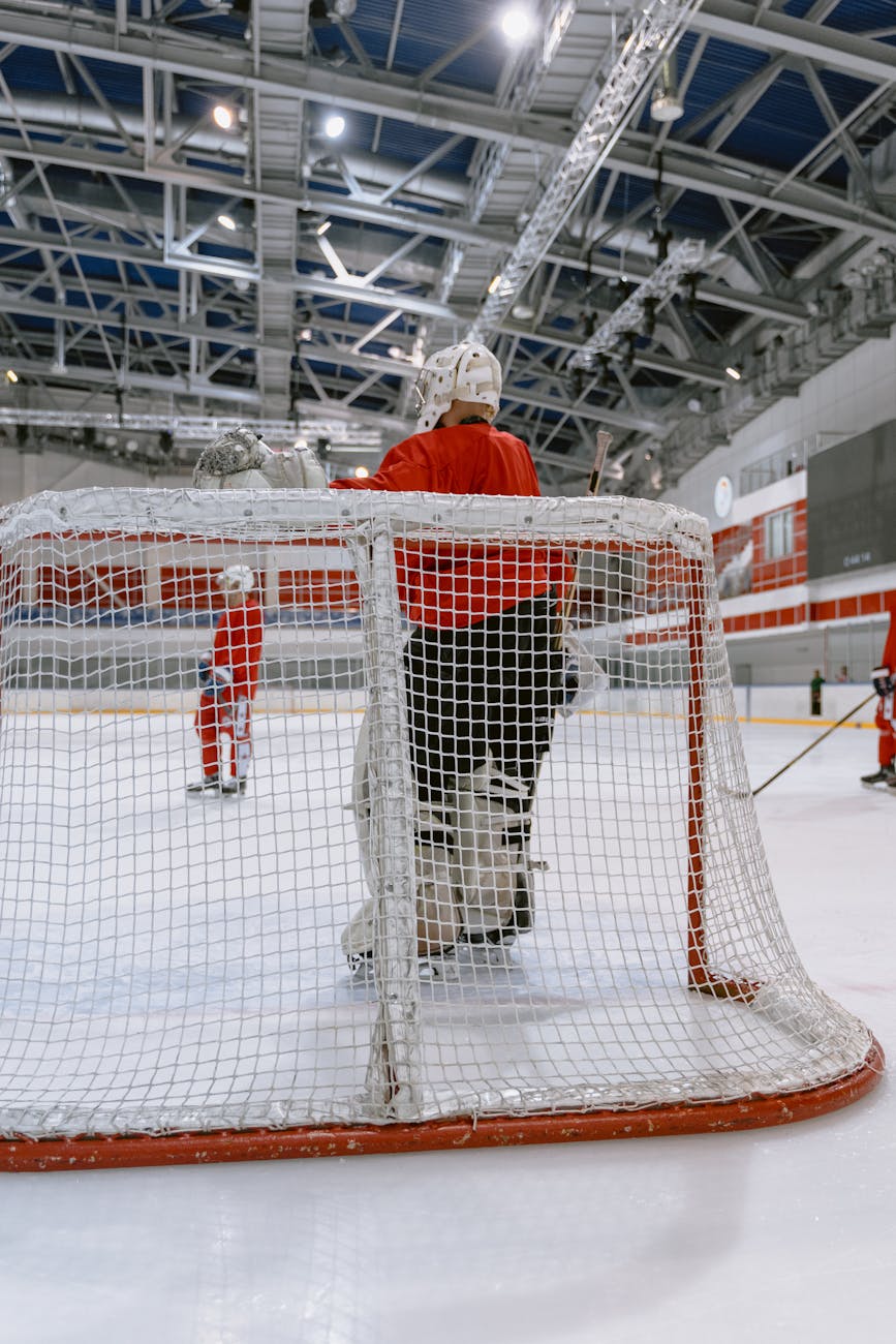 person in red uniform standing near white net