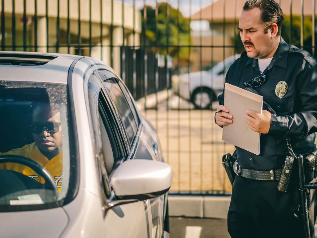 police officer talking to the driver of the silver car