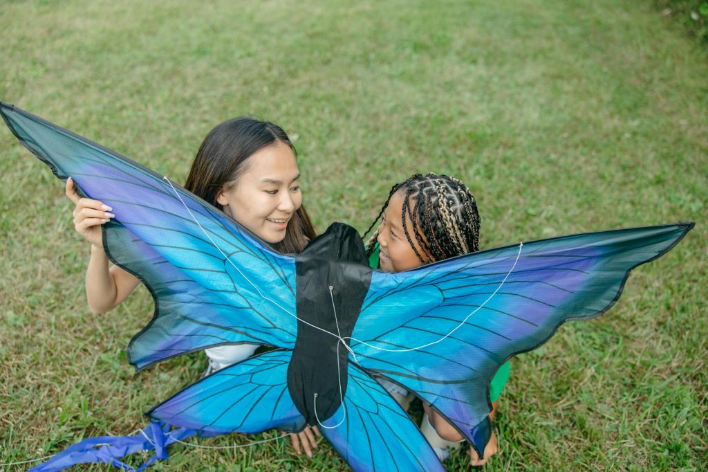 a woman and a girl holding a kite together