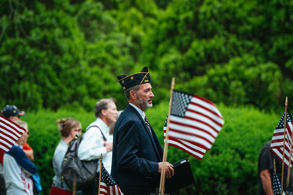 view of people walking on the street with american flags