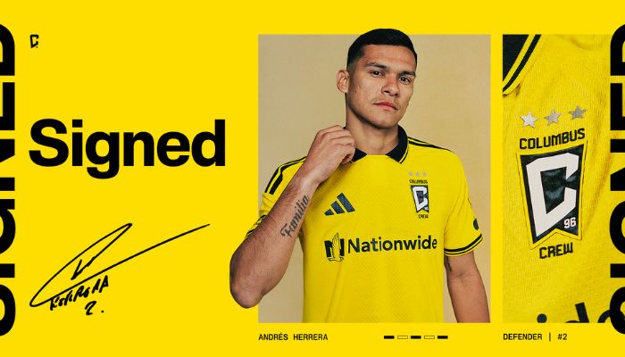 A man wearing a yellow soccer jersey with "Nationwide" and "Columbus Crew" logos, posing with his hand on his chin.
