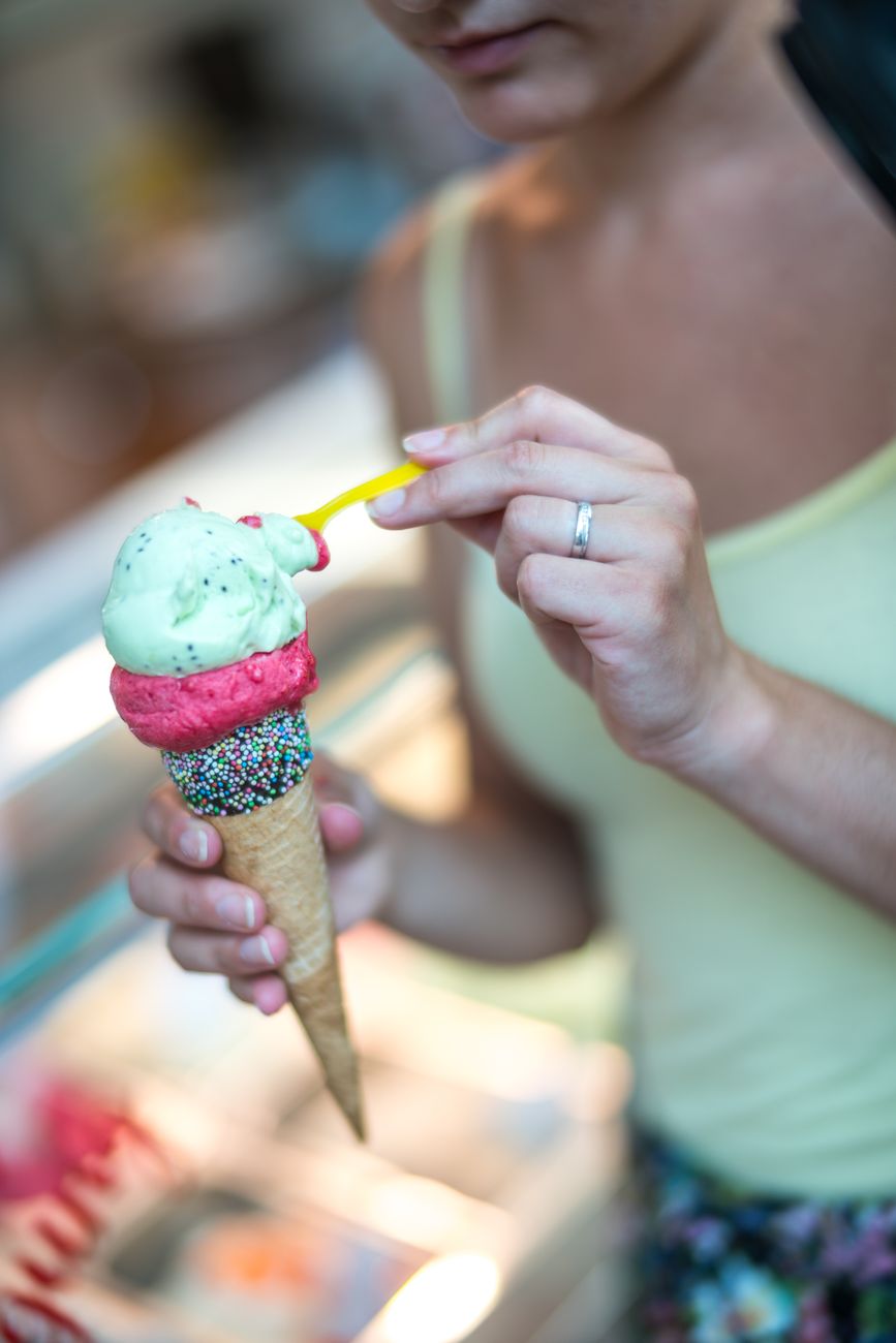 selective focus photography of woman holding ice cream in cone