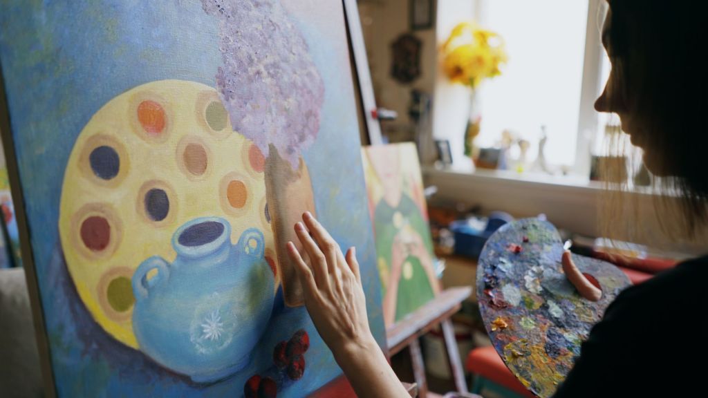 artist creating vibrant still life painting indoors