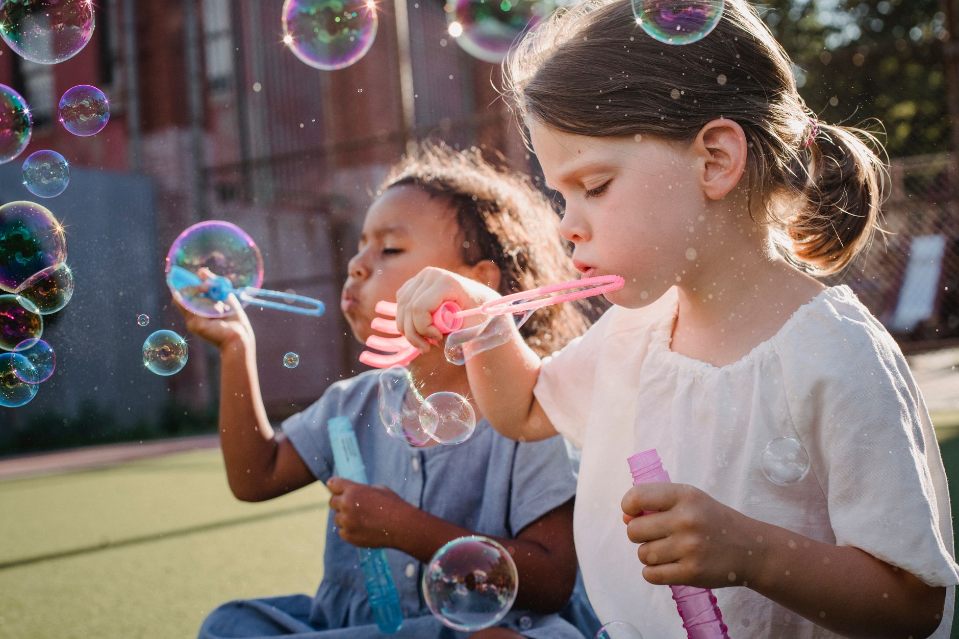 a pair of girls blowing bubbles