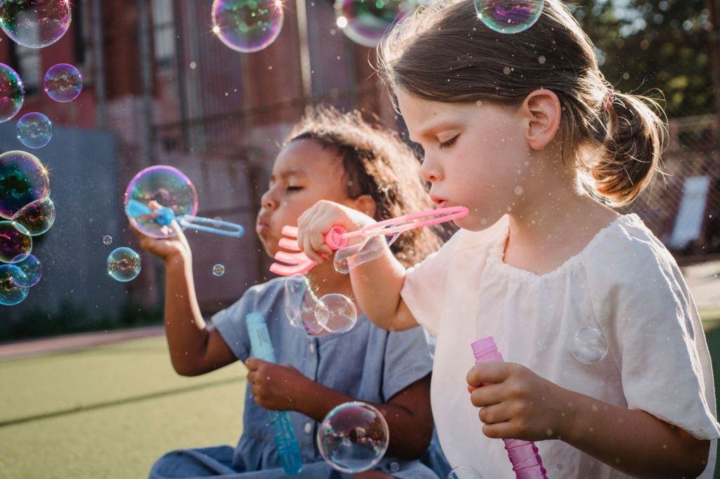 a pair of girls blowing bubbles