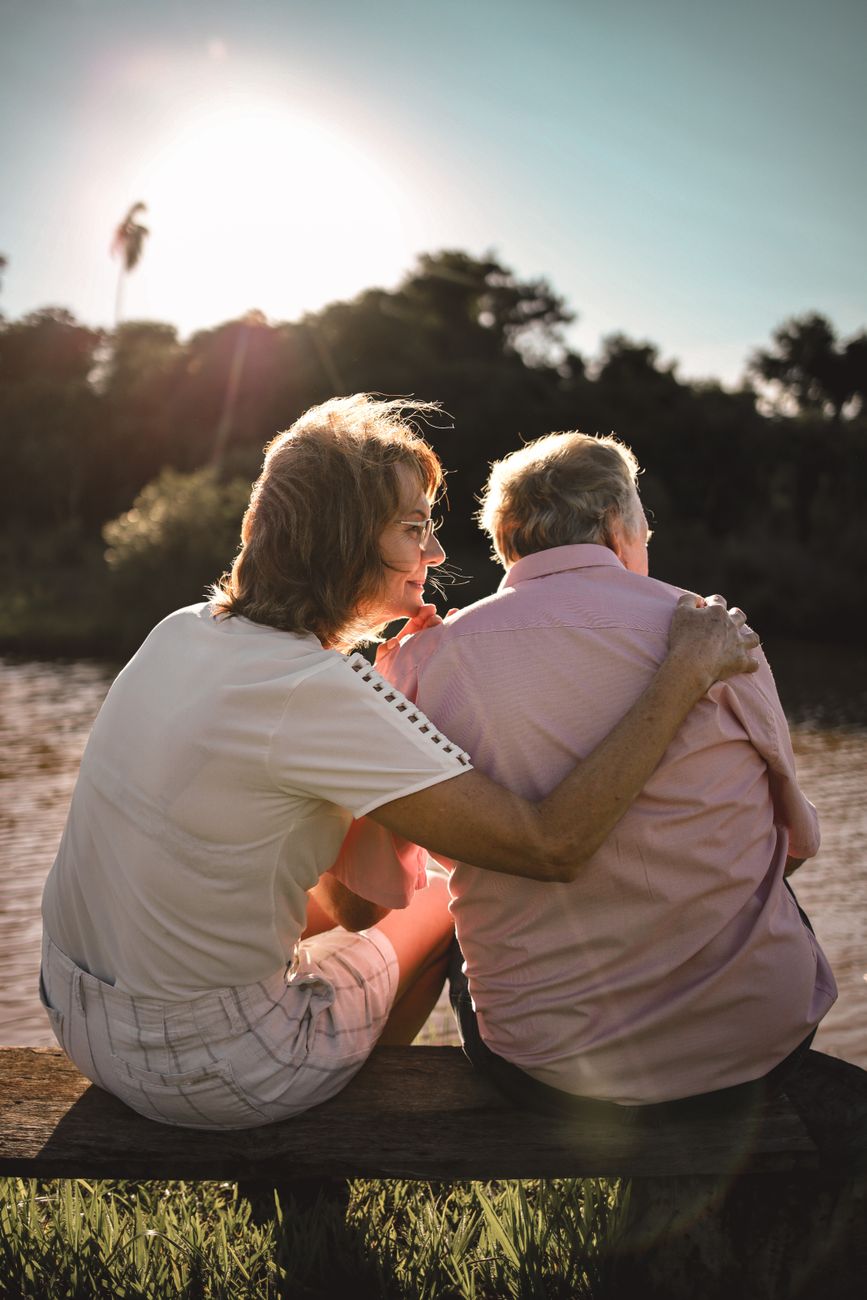 mature couple sitting by the river on a bench