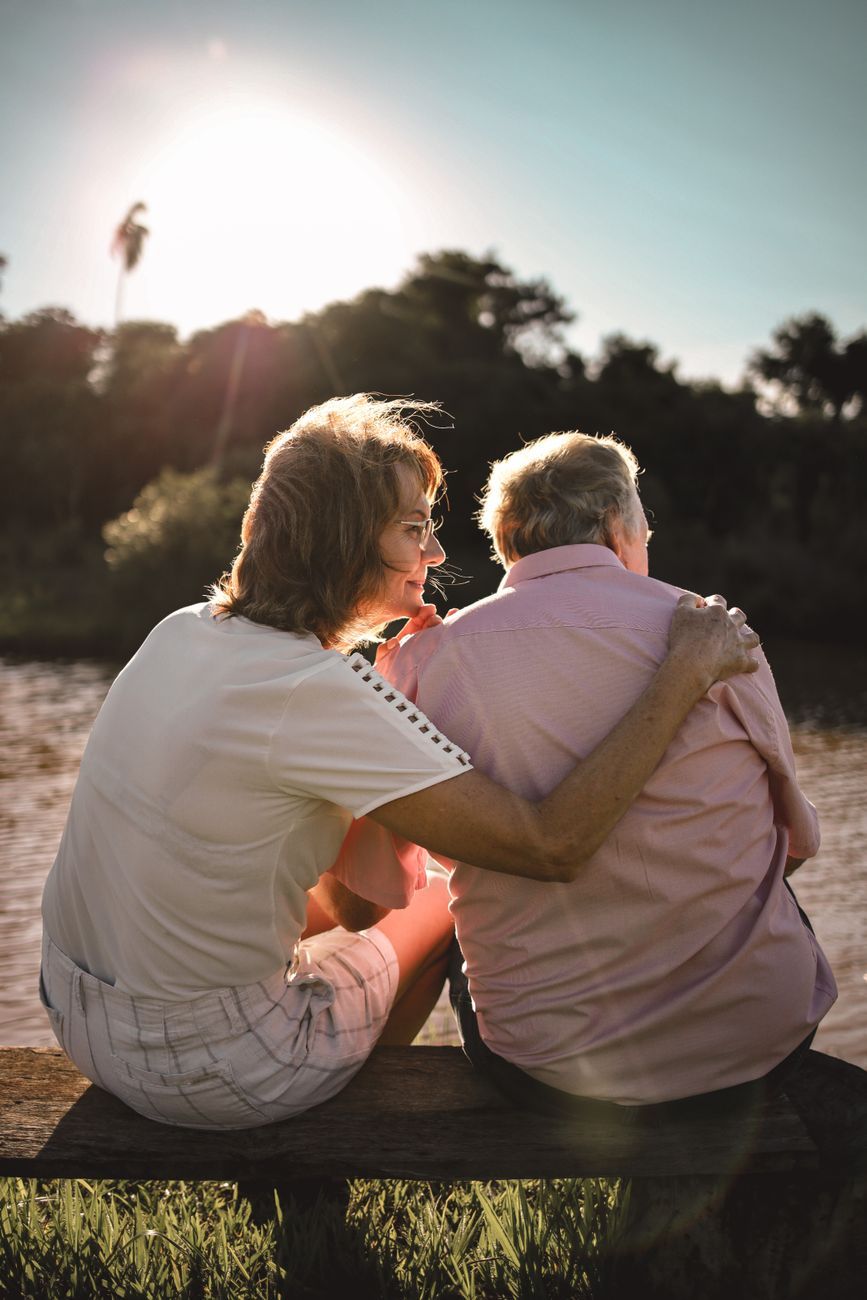 mature couple sitting by the river on a bench