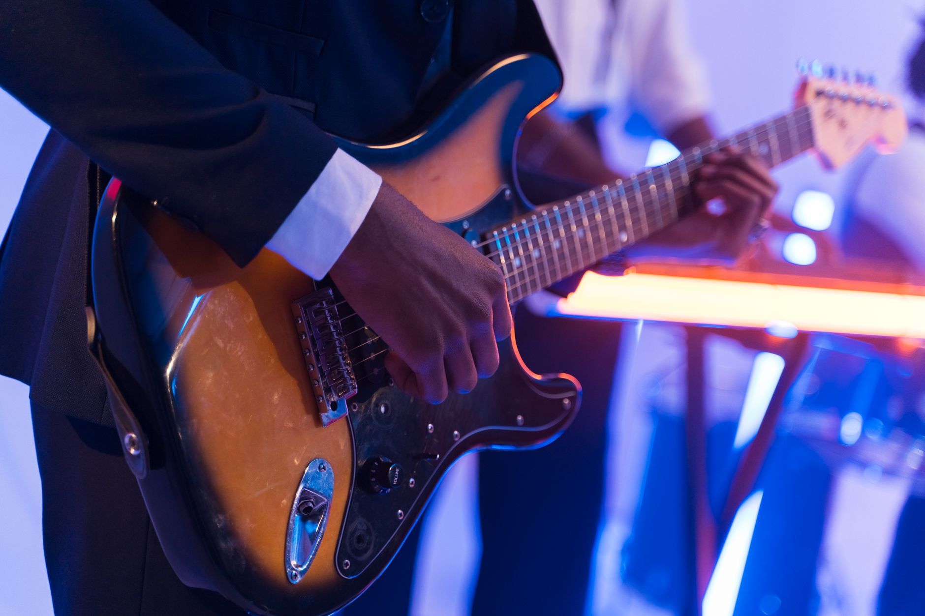 hands playing electric guitar